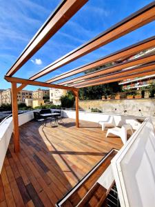 a deck with tables and chairs on a roof at Domus Neapolis Happy Holiday in Naples