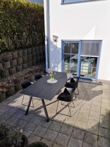 - une table et des chaises noires sur la terrasse dans l'établissement Ostseestern-Rügen 80m² Ferienwohnung Sassnitz, à Sassnitz