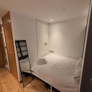 ein kleines weißes Schlafzimmer mit einem Bett und einer Leiter in der Unterkunft OCEAN SPA Suite 11-Hosted by Sweetstay in Gibraltar