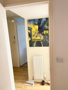 a hallway with a painting on the wall and a radiator at One Bed Flat by Colindale Tube station in Colindale