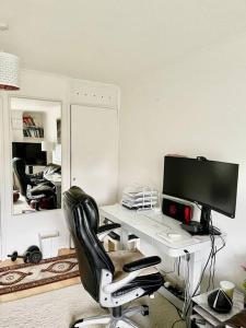 a computer desk with a monitor and a chair at YEBSS Apartment Colindale in Colindale