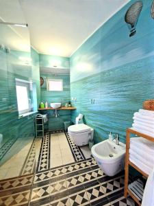 a blue bathroom with a sink and a toilet at Casa con terrazza esclusiva vicino al mare Domus Neapolis Happy Holiday in Naples +31 photos