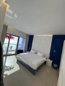 a bedroom with a large bed and a large window at برج داماك الكورنيش الجناح اليوناني Damac jeddah Tower in Jeddah +15 photos
