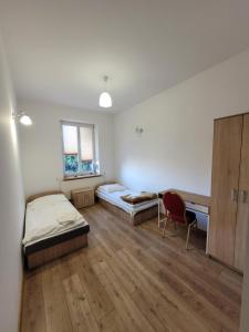 um quarto com duas camas e uma secretária em Dworek Sobieskiego em Skierniewice