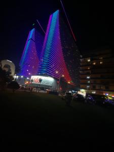 um grupo de edifícios altos iluminados à noite em Orbi City sea view em Batumi