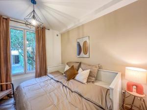 a bedroom with a bed and a window at Charmant T2 au Cœur de la Ville in Tarbes