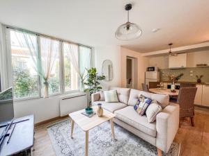 a living room with a couch and a table at Charmant T2 au Cœur de la Ville in Tarbes