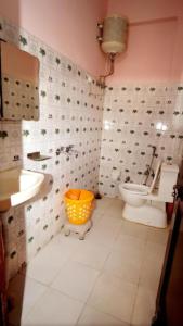 y baño con aseo, lavamanos y cubo. en Hotel Thakur Home's Mountain View - Outdoor furniture - Picnic Area, en Jutogh
