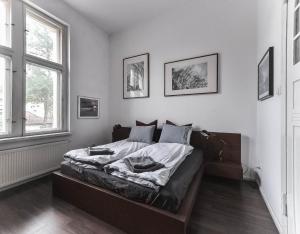 a bedroom with a bed and two windows at Stylowy Park Apartment Wawrzyniaka in Wrocław