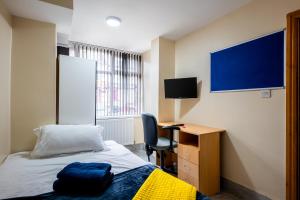 Schlafzimmer mit einem Bett, einem Schreibtisch und einem TV in der Unterkunft Private Rooms With Private Bathrooms In Selly Oak Birmingham in Birmingham