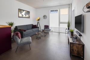 - un salon avec un canapé et une télévision dans l'établissement Casa Milla, Apartment Langenthal, à Langenthal