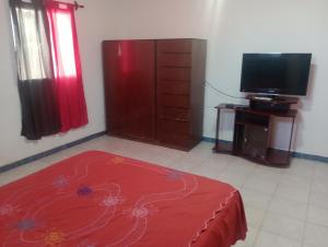 a living room with a red bed and a television at La turca in San Miguel de Tucumán