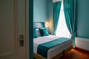 Un dormitorio con una cama con paredes azules y una ventana en Hotel Rosa Bianca en Rapallo