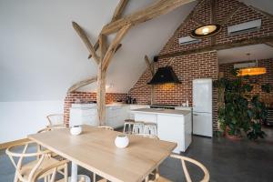 a kitchen with a table and chairs and a brick wall at Les gîtes de la Grange de Léonie - jacuzzis privatifs et Piscine in Vierzon