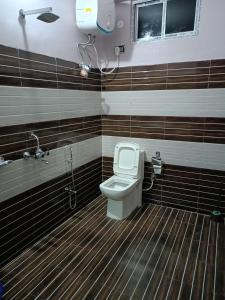 a bathroom with a toilet and a shower at Hilsan Hotel in Bomdila