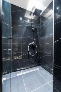 a bathroom with a shower with a glass door at luxueux appartement 5 chambre in Brussels