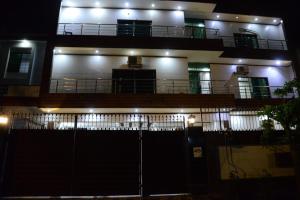 a building with a fence in front of it at night at Go Guest House Lahore in Lahore