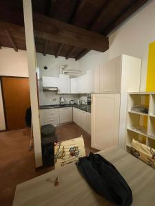 una cucina con armadi bianchi e un letto in una camera di Residenza Marconi centro storico a Budrio