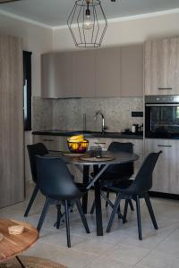 uma cozinha com uma mesa e cadeiras numa cozinha em Seaside House for 10 em Candia