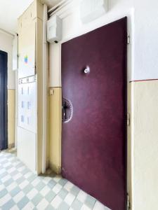 Puerta morada en una habitación con suelo de baldosa en Apartman Sweet home, en Humenné