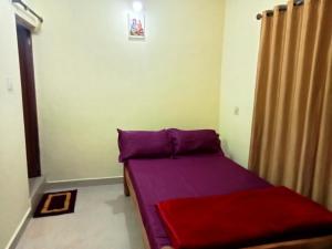 ein kleines Schlafzimmer mit einem lila Bett in einem Zimmer in der Unterkunft soms estate stay in Madikeri