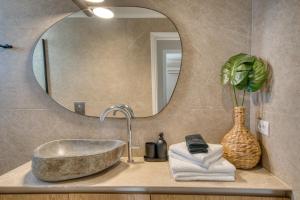 uma casa de banho com um lavatório e um espelho em Seaside House for 10 em Candia