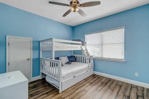een blauwe kamer met een stapelbed en een plafondventilator bij Stunning Ocean Villa-Luxurious Ponte Vedra Living in Jacksonville Beach