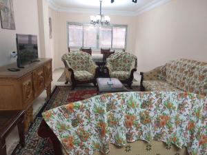 a living room with a couch and chairs and a tv at مصر الجديدة in Sīdī Sālim