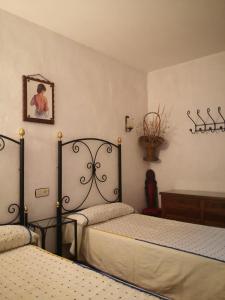 a bedroom with two beds and a picture on the wall at Cuevas del Torreón -- Nueva Dirección in Castilléjar