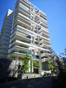 a tall white building with trees in front of it at Exclusive Apt Parque San Damian in Santiago