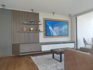 a living room with a flat screen tv on a wall at Exclusive Apt Parque San Damian in Santiago