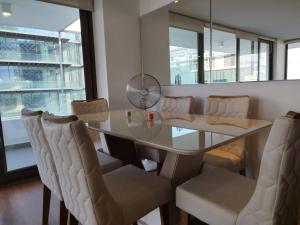 a dining room with a glass table and chairs at Exclusive Apt Parque San Damian in Santiago