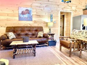 a living room with a brown leather couch and tables at Helen's Hideaway-Wooded seclusion 1 mile to Deep Creek Smoky Mtn Park in Bryson City