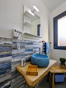 a bathroom with a blue sink and a mirror at I colori della Sicilia in Cinisi
