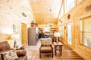 a living room with wooden walls and a refrigerator at Helen's Hideaway-Wooded seclusion 1 mile to Deep Creek Smoky Mtn Park in Bryson City +29 photos