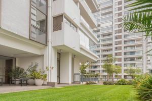 an apartment building with a lawn in front of it at Exclusive Apartment In San Damian, Vitacura in Santiago