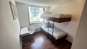 a small room with two bunk beds and a desk at Exclusive Apartment In San Damian, Vitacura in Santiago