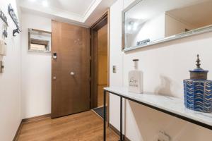 a bathroom with a counter with a mirror and a door at Exclusive Apartment In San Damian, Vitacura in Santiago +46 photos