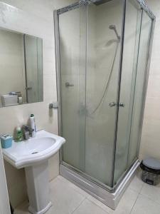 ein Bad mit einer Dusche und einem Waschbecken in der Unterkunft Mirvari in Sumqayıt
