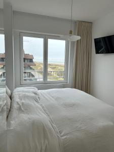 מיטה או מיטות בחדר ב-Hoekappartement 'Westdiep' met zeezicht te Oostduinkerke - Bad