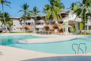 ein Schwimmbad mit einem Resort im Hintergrund in der Unterkunft PLAYA PALMERAS PALMERAS BEACH RESORT in Cartagena de Indias
