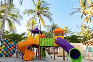 einen Spielplatz mit Rutsche vor Palmen in der Unterkunft PLAYA PALMERAS PALMERAS BEACH RESORT in Cartagena de Indias