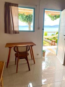 einen Tisch und einen Stuhl in einem Zimmer mit Meerblick in der Unterkunft Surf Shack Grupuk in Bumbang