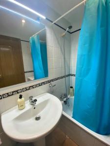 łazienka z umywalką i niebieską zasłoną prysznicową w obiekcie Cool Loft at the beach w mieście Cullera