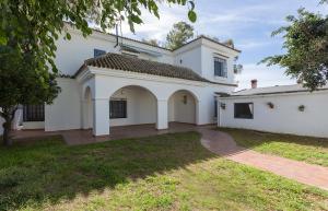 une grande maison blanche avec une allée. dans l'établissement Azvalia Valdeazahares, à El Puerto de Santa María