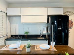 une cuisine avec un réfrigérateur noir et une table en bois dans l'établissement LINDA VISTA c piscina, sauna, garagem e academia, à São Paulo 72 autres photos