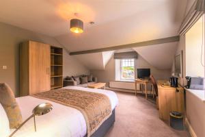 Habitación de hotel con cama grande y TV en The Lamplighter Dining ~ Rooms, en Windermere