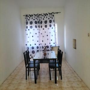 a dining room with a table and chairs and a curtain at Aurelia Nelly in Ukunda +10 photos
