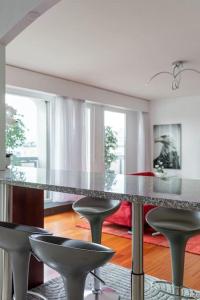 - une salle à manger avec une table et des tabourets dans l'établissement Perle rare nations, à Genève