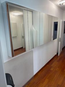 um quarto com armários brancos e um espelho grande em Perle rare nations em Genebra